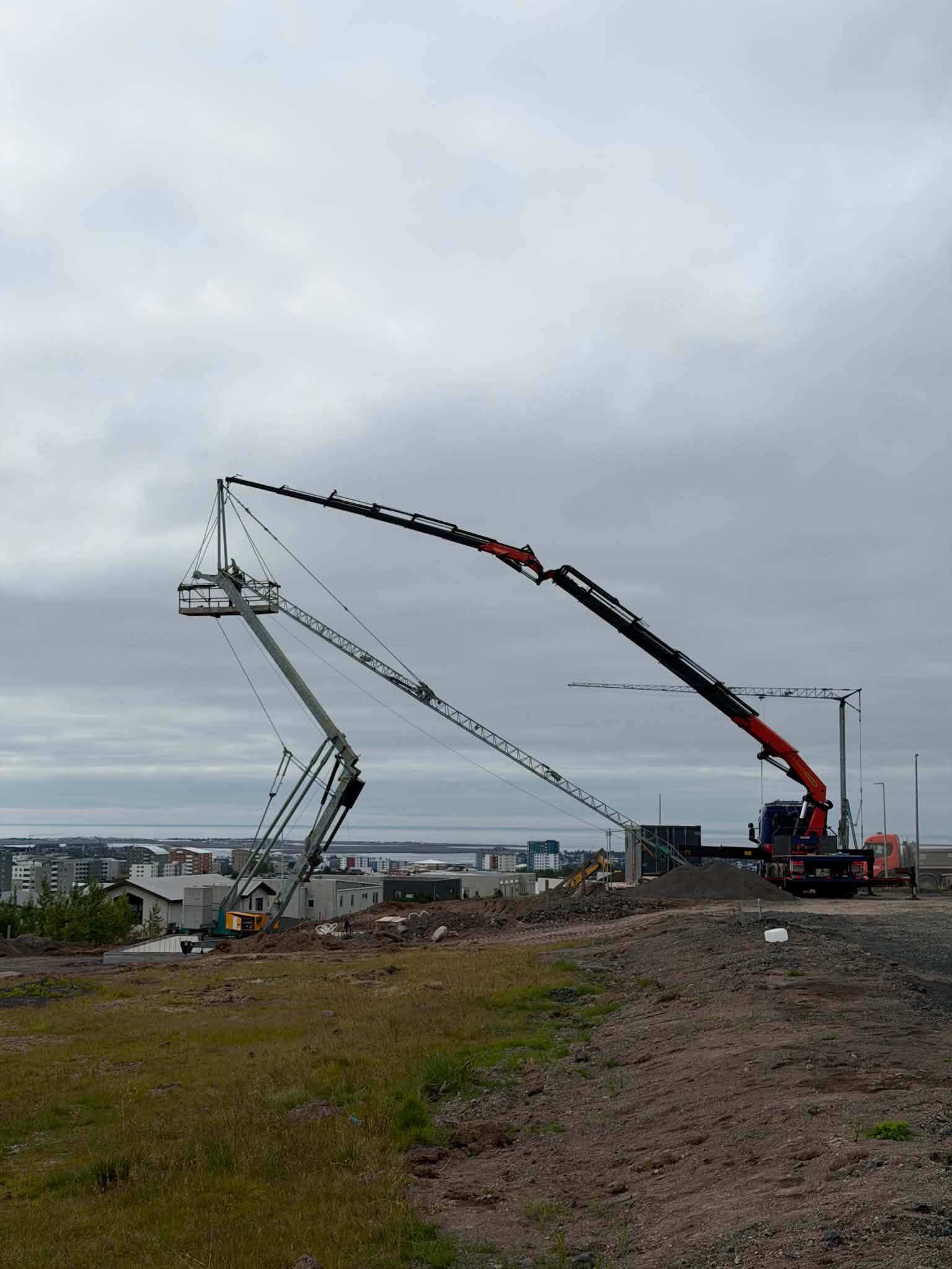 Kranabíll við hífingu og uppsetningu byggingakrana á verkstað.